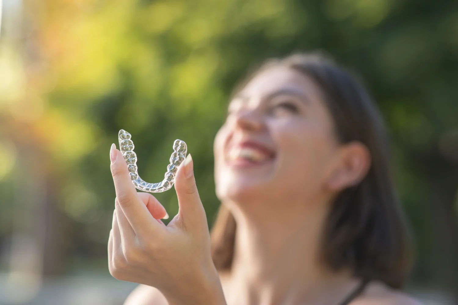 Patient viewing clear dental aligner at Denova Dental